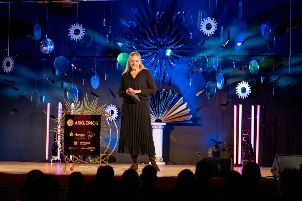 Moderatorin Juliane Möcklinghoff auf der Bühne beim Hamburger SportTalent 2026 in der Aula der Schule Alter Teichweg