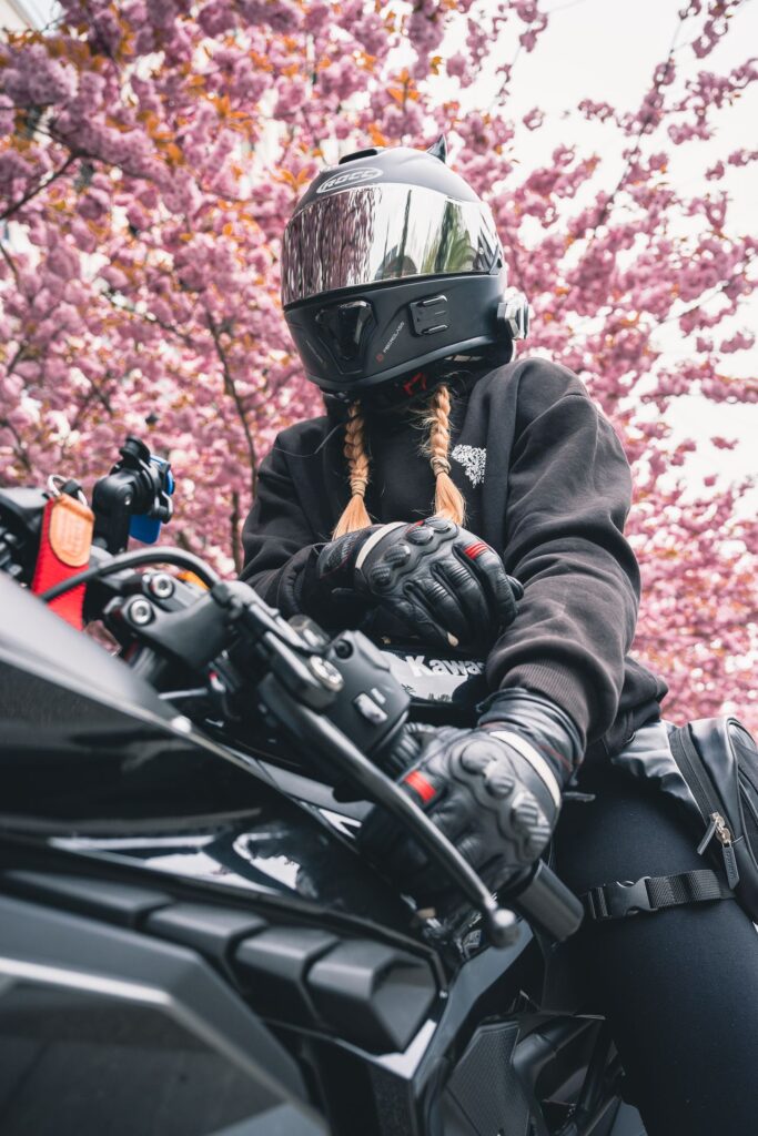 Motorradfahrerin mit Kawasaki vor Kirschblüten