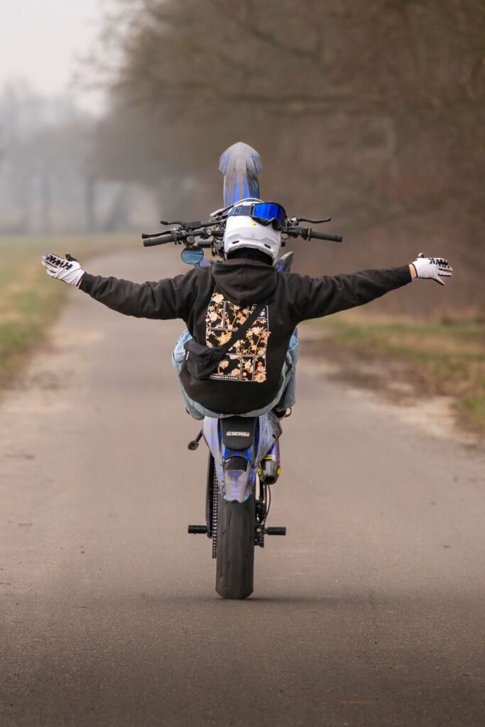 Supermoto-Wheelie mit ausgebreiteten Armen